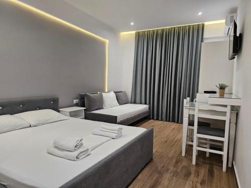 ein Hotelzimmer mit einem Bett, einem Schreibtisch und einem Sofa in der Unterkunft Vila 31 in Sarandë