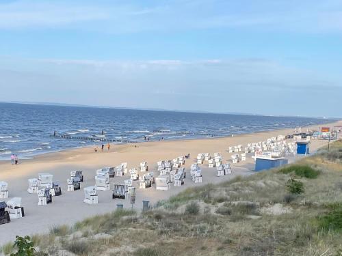 a beach with white chairs and the ocean at Ferienhaus Am Achterwasser in Ueckeritz