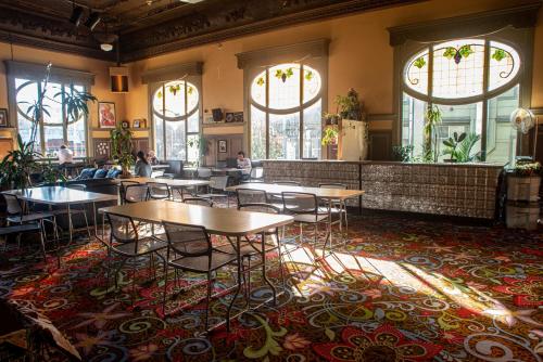 a restaurant with tables and chairs in a room with windows at Green Tortoise Hostel in San Francisco
