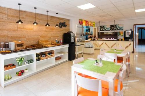 ein Restaurant mit Tisch und Stühlen und einer Küche in der Unterkunft Hotel Vista Sol Cala Rajada in Cala Ratjada