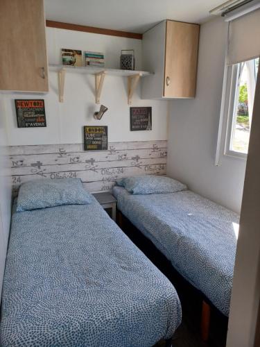 Cette petite chambre comprend 2 lits. dans l'établissement Mobil-home vue océan/400 m de la plage à Saint Jean de Luz, à Saint-Jean-de-Luz