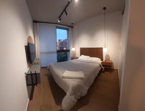 a bedroom with a large bed and a large window at Edificio Hassler Villamorra in Asuncion