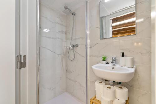 a white bathroom with a sink and a shower at Nice Central Loft in Vilanova i la Geltrú