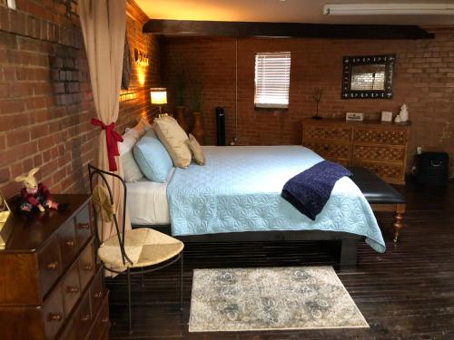 a bedroom with a bed and a brick wall at Dallas Farmers Market Area, Just right in Downtown in Dallas