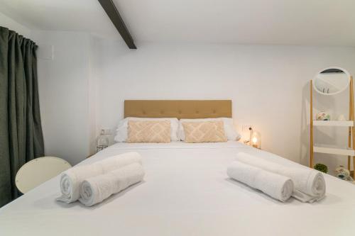 un grande letto bianco con due cuscini sopra di Nice Central Loft a Vilanova i la Geltrú