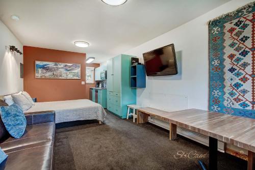 a bedroom with a bed and a tv and a couch at Completely Renovated Unit, Trendy Top Floor with Many Onsite Amenities PM7D in Breckenridge