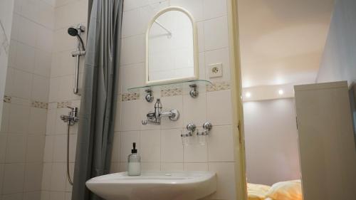 a bathroom with a sink and a shower with a mirror at Apartment Jursport in Závažná Poruba