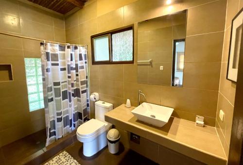 uma casa de banho com um lavatório, um WC e um espelho. em Sauce Lodge - Laguna Azul em Sauce