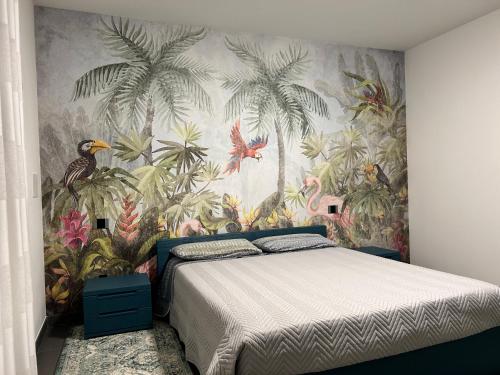 een slaapkamer met een bed met tropisch behang bij Casa di Marco in Pescantina