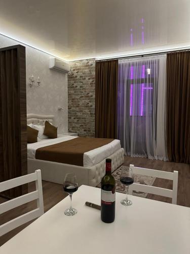 a room with a bed and two glasses of wine on a table at Moonlight Apart-Hotel Batumi in Batumi