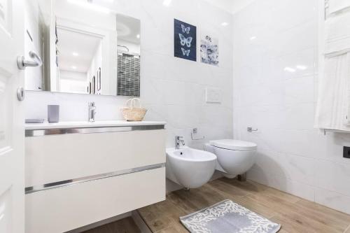 a white bathroom with a toilet and a sink at Cozy Terrace in Portofino [Free Parking] in Portofino