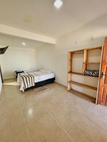Un dormitorio con una cama y estanterías. en Pousada Serra de São Thomé, en São Thomé das Letras