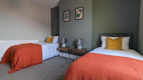 a bedroom with two beds and two night stands at Peaceful 4 - Bedroom Home - Fast WiFi - Ideal for Work , Free Parking in Wolverhampton