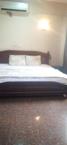 1 dormitorio con 1 cama con 2 almohadas blancas en Ypool Pacific Homes, en Kumasi