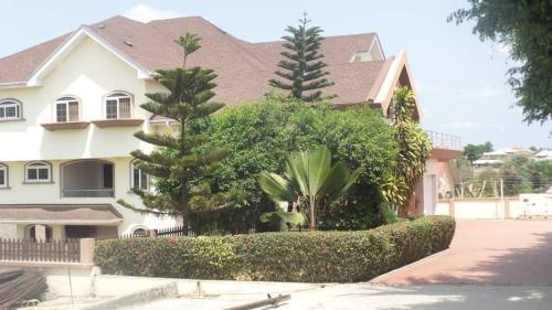 una casa con árboles y arbustos delante de ella en Ypool Pacific Homes, en Kumasi