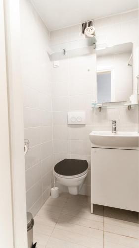 a white bathroom with a toilet and a sink at House Gorica in Šibenik