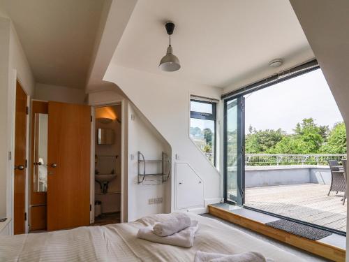 een slaapkamer met een bed en een groot raam bij The Penthouse in Lyme Regis
