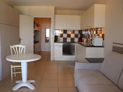 Il dispose d'une cuisine et d'un salon avec une table et un canapé. dans l'établissement Studio cabine climatisé avec terrasse, parking, animaux admis - FR-1-100-184, à Cavalaire-sur-Mer