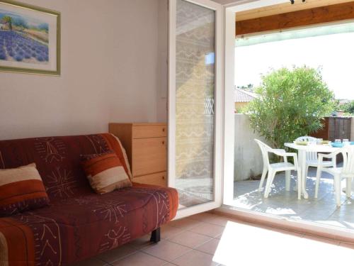 un salon avec un canapé et une porte coulissante en verre dans l'établissement Pavillon à Narbonne Plage, 6 couchages, terrasse, à 300m de la plage, parking, ménage inclus - FR-1-229B-24, à Narbonne