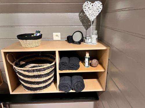 a wooden shelf with towels and a basket on it at Gîte Libre’Air in Redu