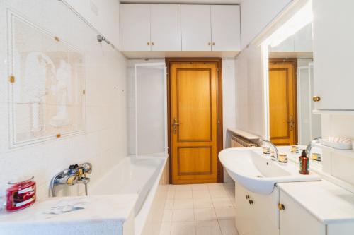 uma casa de banho branca com um lavatório e uma banheira em Casa Ambrogi relax in collina em Valfabbrica