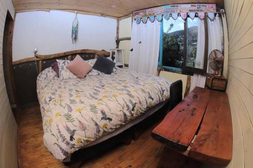 a bedroom with a bed and a wooden table at Maravillosa Cabaña de Montaña. in San Francisco