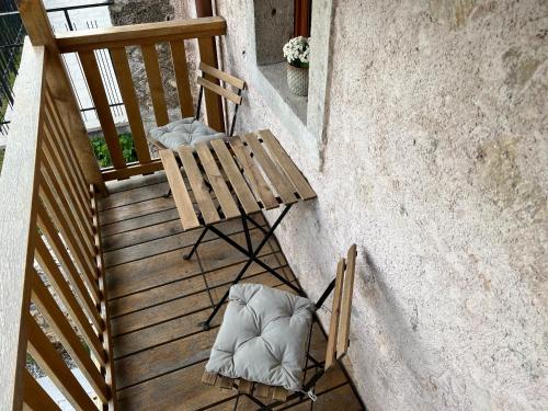 a wooden bench sitting on a porch with a chair at Appartamenti Minerva in San Pelagio