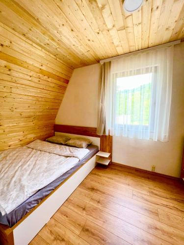 a bedroom with a bed in a wooden room at Villa Dardania in Peje