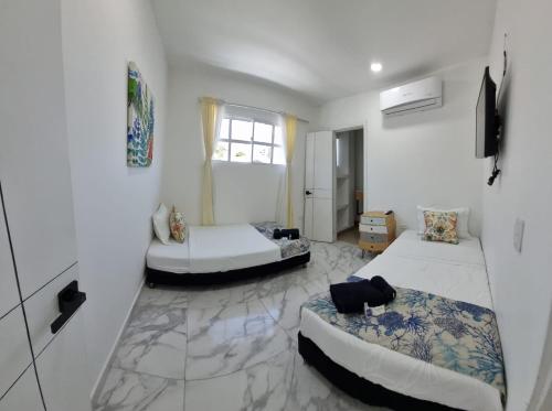 a large room with two beds and a window at Le MARIE B&B in Cartagena de Indias