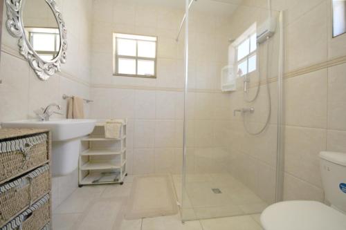 uma casa de banho com um chuveiro, um WC e um lavatório. em Villa Jolie em Noord