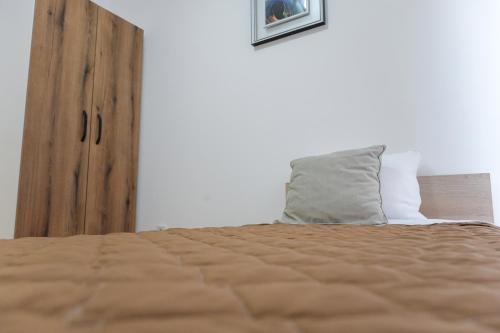 a bedroom with a bed and a wooden door at Porta Apartment in Skopje