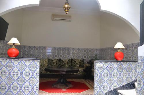 a living room with a couch and two red lamps at Dar tabazariste in Marrakesh