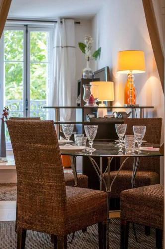 - une salle à manger avec une table, des chaises et des verres à vin dans l'établissement Le Phocéen - T2 46m² avec Balcon - Joliette, à Marseille