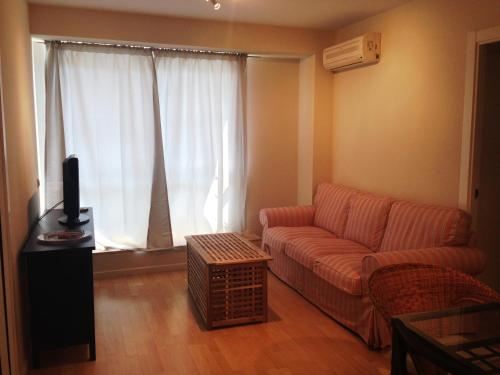 a living room with a couch and a large window at Apartaments Muntaner I in Palamós