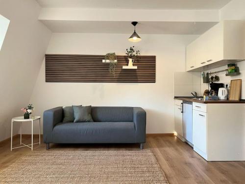 ein Wohnzimmer mit einer blauen Couch in einer Küche in der Unterkunft “Sweet boho penthouse” in city center in Lahr