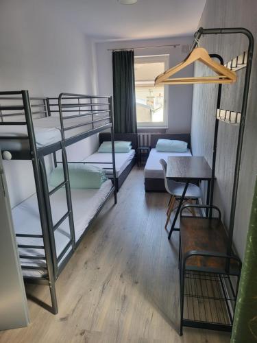 Ce dortoir comprend des lits superposés, une table et une chaise. dans l'établissement Rooms4Rest Wiertnicza - Private rooms for tourists - ATR Consulting Sp, z o,o,, à Varsovie