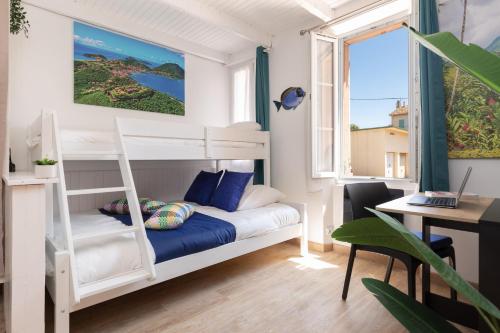 Cette petite chambre comprend des lits superposés et un bureau. dans l'établissement Sweet Caraib - Cosy - Mer - Wifi - Host Provence, à La Seyne-sur-Mer