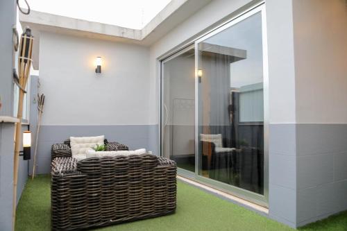 Una sala de estar con una silla y una ventana. en Terrazza Piccinni, en Bari