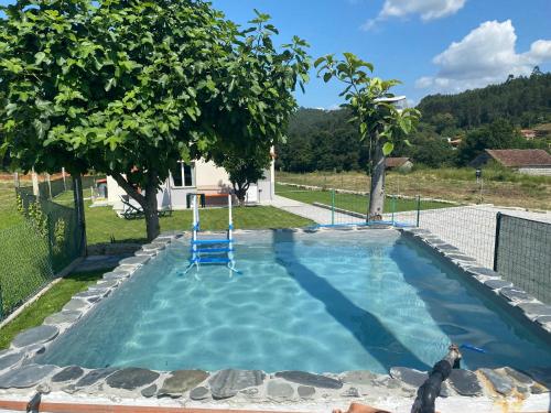 - une piscine avec une chaise bleue dans la cour dans l'établissement Casa da Nora, à Póvoa de Lanhoso