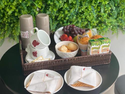 een dienblad met eten op een tafel met fruit en muffins bij Motel Sedución (Adults only) in Cascavel