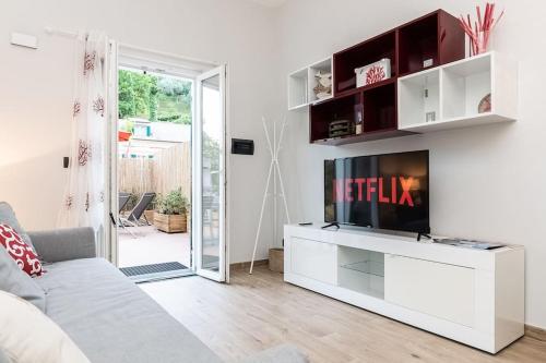 a white living room with a tv and a couch at Portofino's Little Nest [Wi-Fi & A/C] in Portofino