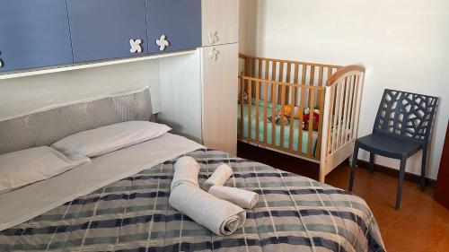 ein Schlafzimmer mit einem Bett mit einem Kinderbett und einem Stuhl in der Unterkunft Villa Mediterranean Sunset in Punta Braccetto