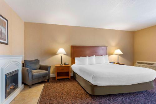 a hotel room with a bed and a chair at Best Western Plus Placerville Inn in Placerville