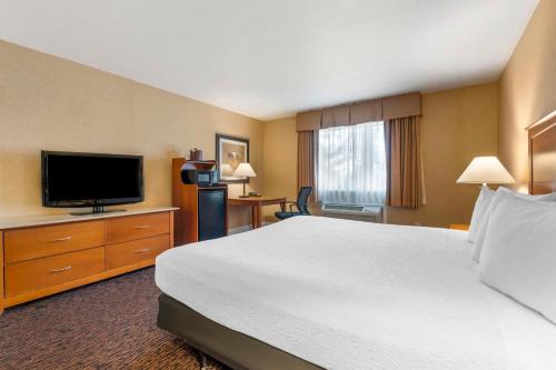 a hotel room with a bed and a flat screen tv at Best Western Plus Placerville Inn in Placerville