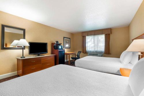 a hotel room with two beds and a flat screen tv at Best Western Plus Placerville Inn in Placerville