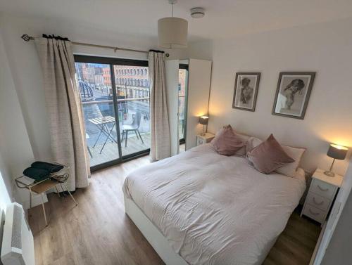 um quarto com uma cama grande e uma janela grande em 2 Bed 2 Bath Flat Central Manchester em Manchester