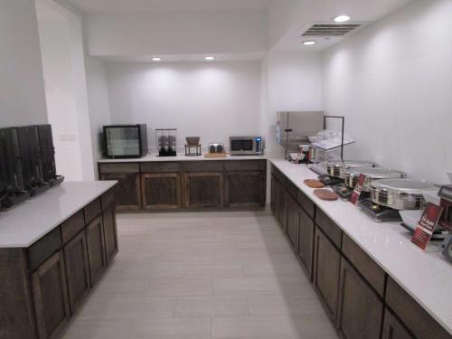 a large kitchen with wooden cabinets and a counter at Reddy Hotel Bonham in Bonham