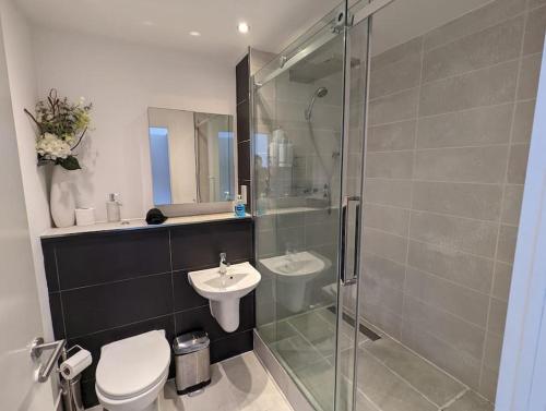 uma casa de banho com um chuveiro, um WC e um lavatório. em 2 Bed 2 Bath Flat Central Manchester em Manchester