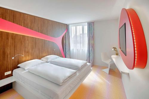 ein Schlafzimmer mit einem weißen Bett und einer roten Wand in der Unterkunft prizeotel Vienna-City in Wien