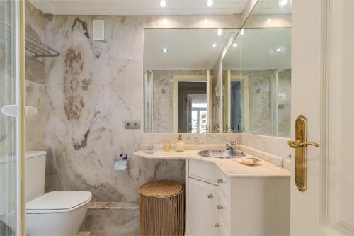 a bathroom with a sink and a toilet and a mirror at El Balcón de Charles in Santander